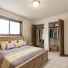 a bedroom with a bed, nightstands, window, and closet. | Eagle Sky II Bismarck, ND