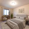 A bedroom with a bed, nightstands, and a window Newgate Apartments |Bismarck, ND