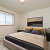  Fargo, ND Essex Apartments. A bedroom with a large window. The room features a comfortable bed, stylish furnishings, and soft lighting, creating a relaxing and peaceful atmosphere.