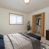  Fargo, ND Essex Apartments. A bedroom with a large window and closet. The room features a comfortable bed, stylish furnishings, and soft lighting, creating a relaxing and peaceful atmosphere.